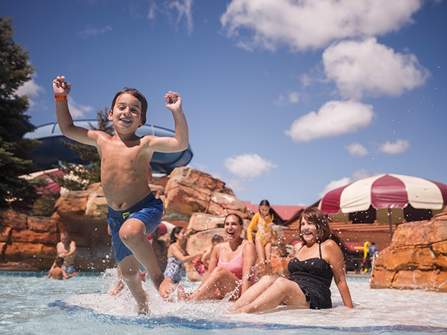 Two people in bright green tube sliding on waterslide