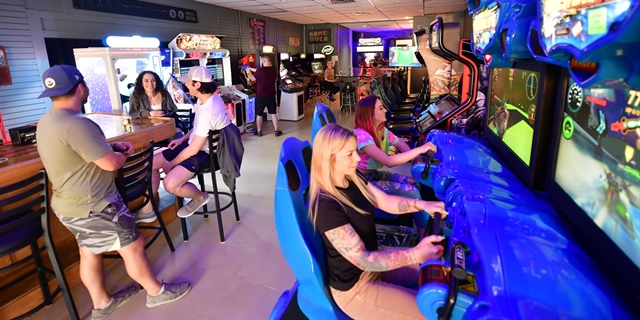 People sitting by a bar and playing games