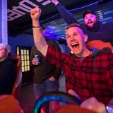 A group of friends playing a racing video game.