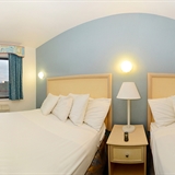 Two bed bedroom with night stand and lamp.