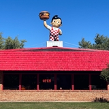 Building exterior with big boy statue on top of the building.