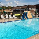 Outdoor pool with slide and poolside seats.