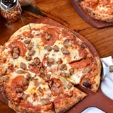 Pizza, pasta and wings on a table.