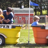 A family rides in little wagons.