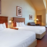 Two-bed bedroom with fireplace, sofa, and coffee table.