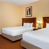 Two-bed bedroom with sofa, coffee table, and outdoor patio.