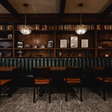 Dark speakeasy room with leather seating.