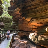 A woman walks through a scenic gorge.