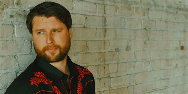 derek james in front of wall