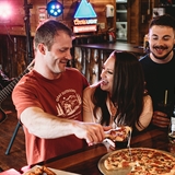 A group enjoying food and drinks while listening to live music.