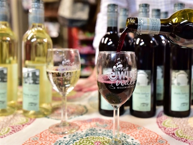 Wine pouring into glasses on a table at Fall Wine Walk
