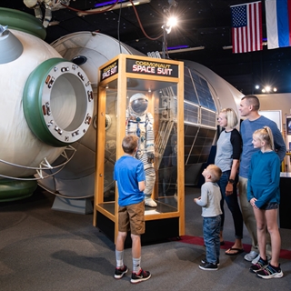 Family looking at a space exhibition at Tommy Bartlett Exploratory.
