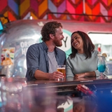A couple enjoying drinks at the Grateful Shed bar.