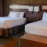 Two bed bedroom with fireplace, chair, and television.