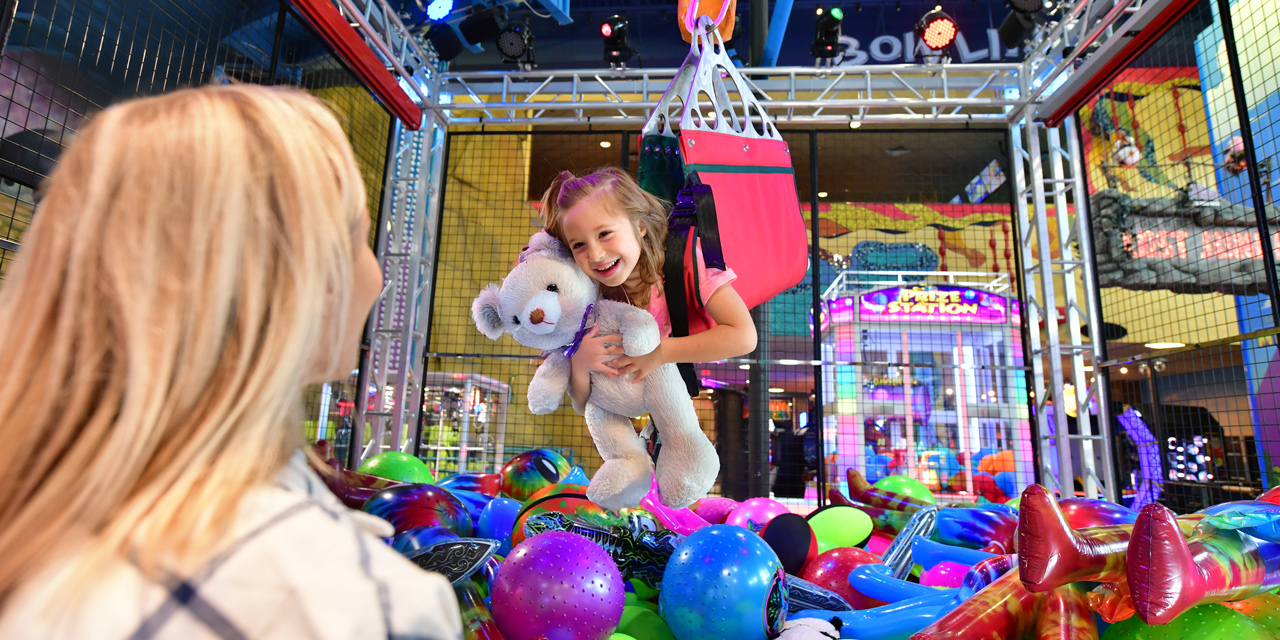 Little girl on a human claw machine ride.