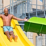 Father and daughter sliding down a waterslide.