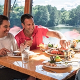People enjoying food inside overlooking the lake.