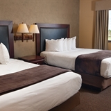 Two bed bedroom with nightstand and lamps.