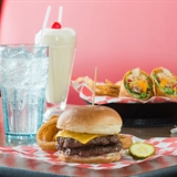 Various menu items from Monk's Bar & Grill - Wisconsin Dells including a cheeseburger, onion rings, milkshake, and chicken wrap.