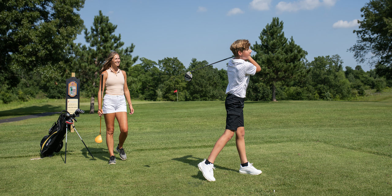 Mother and son playing golf.