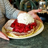 Pancakes with fruit and whipped cream.