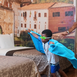 Mom and child playing in a hotel room.