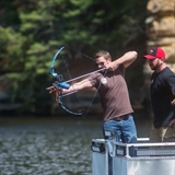 Man bowfishing daytime.