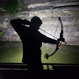 Man bowfishing nighttime.