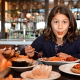 Family eating pasta and pizza dishes.