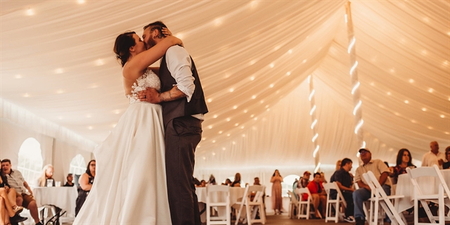 A couple at their wedding with guests.