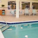 Indoor pool with poolside table and chairs.