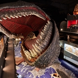 A giant whale eats a rowboat.