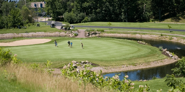 People on the green at The Woods Short Course at Wild Rock.