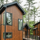 Exteriors of multiple villas tucked in the woods.