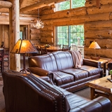 Living and kitchen area at Wilderness Resort with sofas, dining table, chairs, and countertop seating.