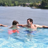 People in a pool overlooking the lake.