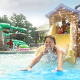 Children play in the kid's waterpark play area.