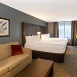 Two bed bedroom with desk, office chair, sofa, coffee table, and television.